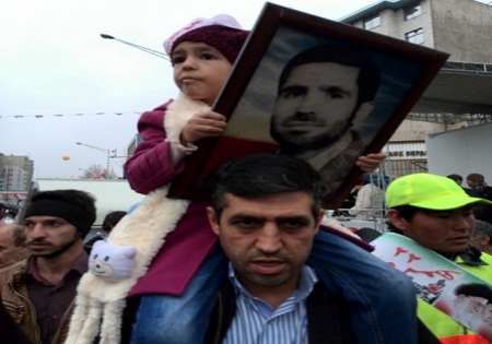 عکس/ نوه و پدر به همراه پدربزرگ شهید در راهپیمایی